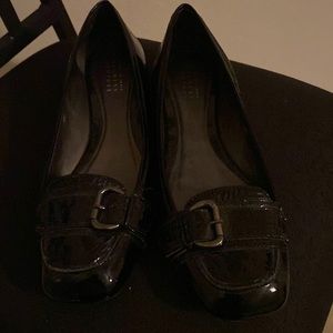 Barney’s Black patent flat with faux buckle.
